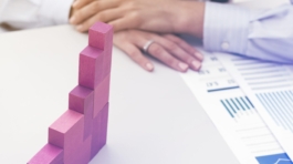 Businesswoman building a growing financial chart with wooden pieces, development and strategy concept