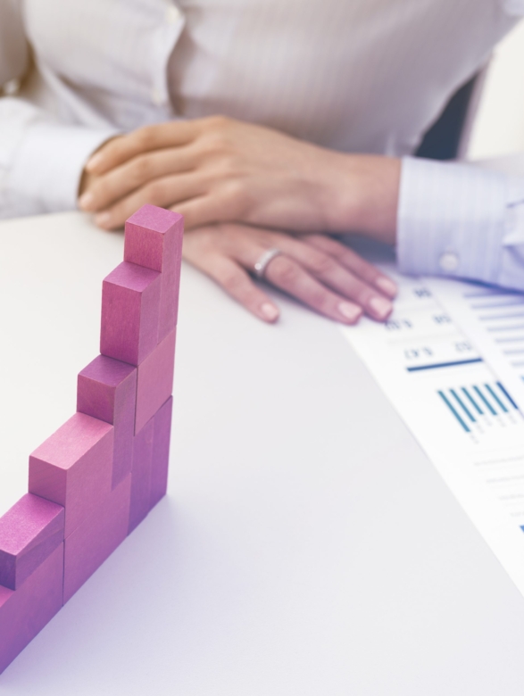 Businesswoman building a growing financial chart with wooden pieces, development and strategy concept
